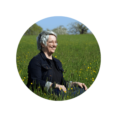 Porträt von Bianca Wenz sitzend in einer Wiese, umgeben von einem kreisförmigen Schriftzug: „Bianca Wenz – Meine Passion: Prozessoptimierung“.